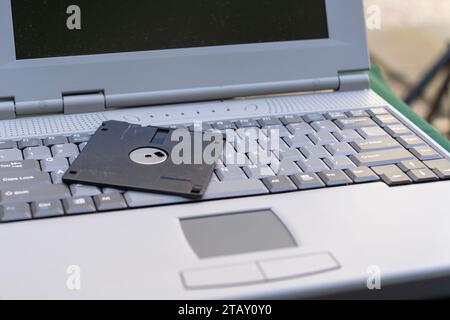 Old gray notebook with black 3.5 inch floppy disk Stock Photo