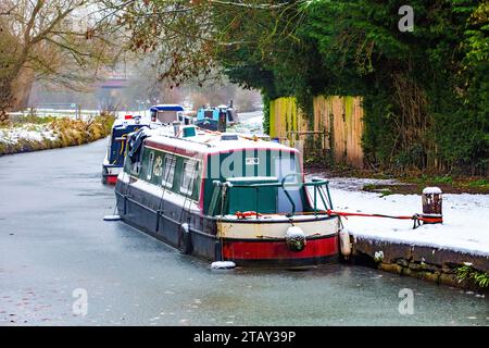 Canal narrowboat moored on the Trent and Mersey canal in the snow during winter at Wheelock locks Cheshire England UK Stock Photo