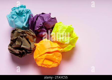 Crumpled Colorful Paper Balls on Pink Background, Uselessness Concept Stock Photo