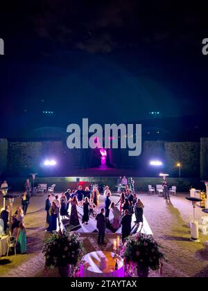 Rome, Italy - 09 august 2023: Guests dance on the stage in the garden near the laid tables Stock Photo