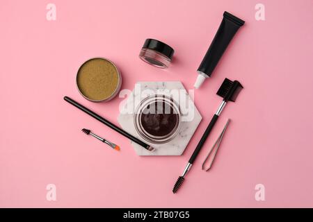 Flat lay composition with eyebrow henna and tools on pink background Stock Photo