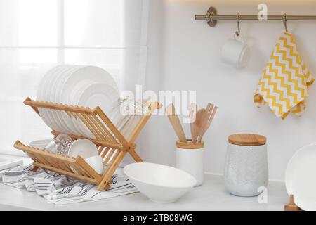 Drying rack with clean dishes on countertop in kitchen Stock Photo