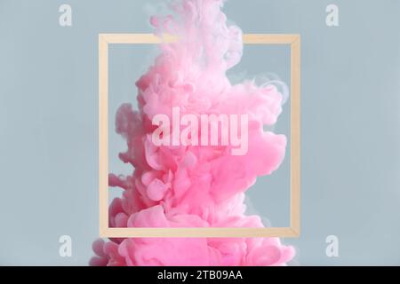 Splash of pink ink and frame on grey background Stock Photo