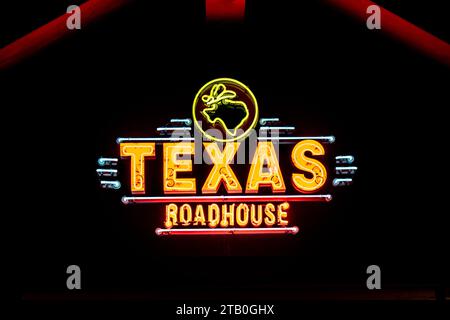 WOODBURY, MN, USA - DECEMBER 4, 2023: Texas Roadhouse restaurant exterior and trademark logo at night. Stock Photo