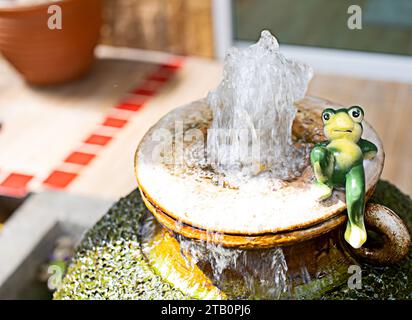 small fountain and frog in a large red earthenware jar in the home or garden Stock Photo