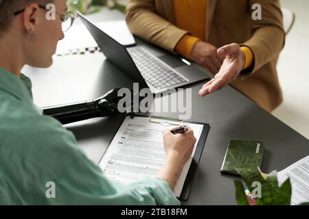 High angle view of woman with disability filing documents while having consultation with insurance agent Stock Photo