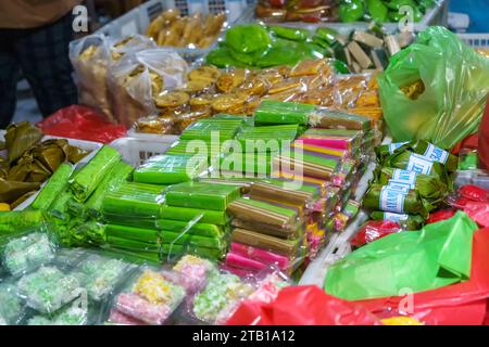 Many varieties of traditional snacks sold in the Marketplace in dawn time in Surabaya, East Java, Indonesia. Street Food Photo Stock Photo