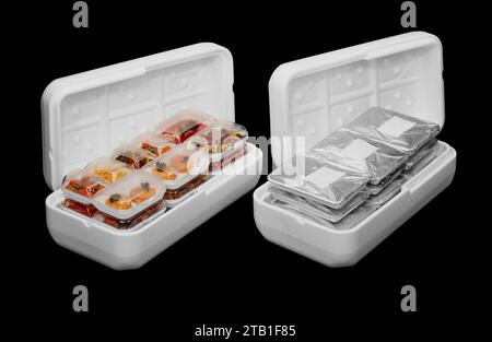 Two open warming boxes made of polystyrene including some food isolated in black back Stock Photo