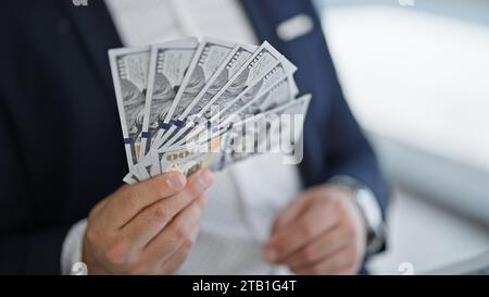 Young latin man business worker using laptop counting dollars at office Stock Photo