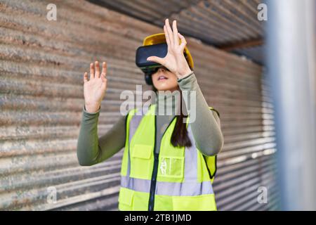 Young beautiful hispanic woman architect using virtual reality glasses at street Stock Photo
