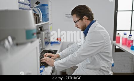Young hispanic man scientist using computer at laboratory Stock Photo