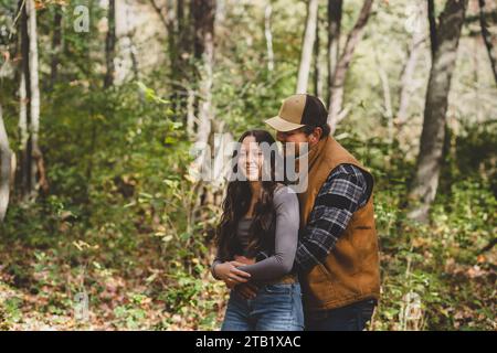 young man hugging girl from behind outside Stock Photo