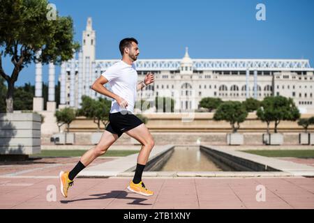 Side view of a runner male athlete training jogging in Barcelona Stock Photo
