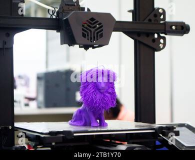 Model of toy lion printed on 3D printer from melted plastic blue color on desktop of 3D printer. Concept 3D printer, 3D printing, modeling prototyping three dimensional object. Innovative production Stock Photo