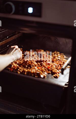 Making homemade oatmeal granola. Rice flakes, nuts and candied fruits. Stock Photo