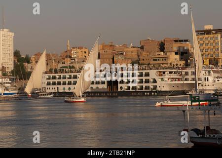 Traditional Felucca sailing the Nile River during golden hour in Aswan Stock Photo