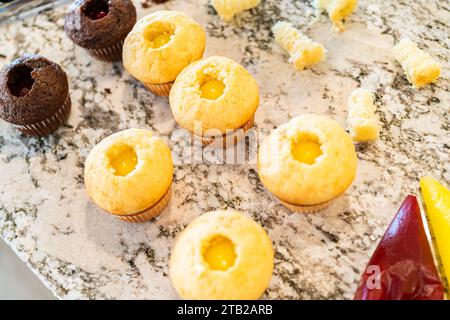 Filling Vanilla, Chocolate Cupcakes with Lemon, Raspberry Stock Photo