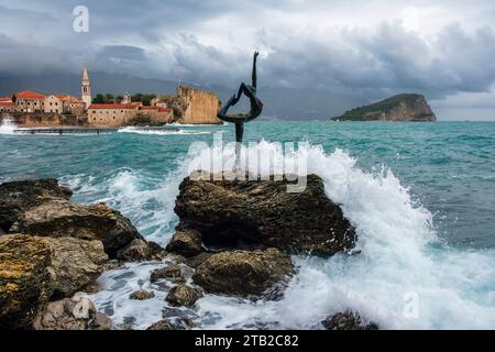 The Mogren Ballerina Statue and view to Budva Old Town on a stormy day, Montenegro Stock Photo