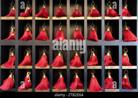 Traditional red key tags in hotel on display Stock Photo