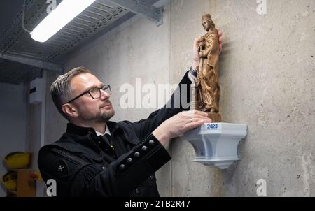 Diera Zehren, Germany. 04th Dec, 2023. Martin Dulig (SPD), Saxony's Minister of Economic Affairs, places a Saint Barbara, patron saint of miners, in the newly built hat house and shaft building at the opening of the new mine of the Meissen porcelain manufactory in Seilitz, wearing a miner's habit. The raw material kaolin has been mined for the manufactory in Seilitz since 1764, first in open-cast mining and from 1825 in underground mining. Credit: Robert Michael/dpa/Alamy Live News Stock Photo