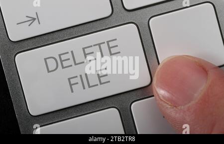 A man pressing a delete file button on a compter keyboard. Stock Photo
