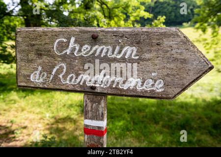 Wooden sign indicating a long-distance hiking trail blazed with characteristic marks consisting of a white stripe above a red stripe Stock Photo