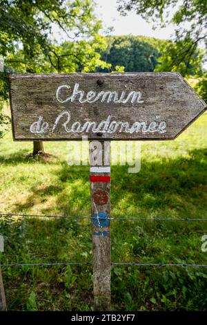 Wooden sign indicating a long-distance hiking trail blazed with characteristic marks consisting of a white stripe above a red stripe Stock Photo