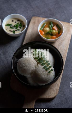 South Indian snacks idli sambar or idly sambhar prepared by steaming fermented rice and served with coconut dip and vegetable soup or sambar. Stock Photo