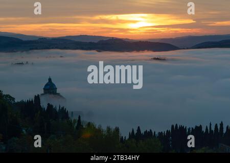 aerial landscape with low morning clouds moisture filling up green valley in Tuscan countryside, shot in bright morning light from Montepulciano, Sien Stock Photo