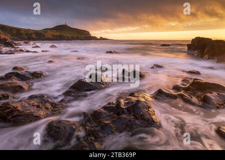 Sunset over Cape Cornwall from the rocky shores of Porth Ledden, Cornwall, England. Spring (May) 2022. Stock Photo