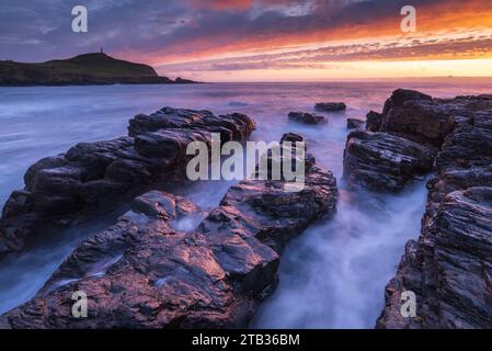 Sunset over Cape Cornwall from the rocky shores of Porth Ledden, Cornwall, England. Spring (May) 2022. Stock Photo