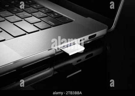Close up view of a memory card inserted into a card reading slot of a laptop computer. Stock Photo
