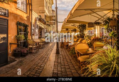 sidewalk with colorful restaurants on the quayside of Nyhavn Canal in Copenhagen, November 25, 2023 Stock Photo