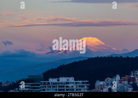 Cayambe volcano at sunset with blue and red tones seen from Quito, Ecuador Stock Photo