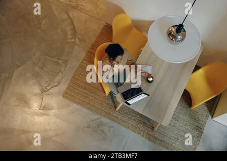 Top view of business woman is talking smartphone while working laptop sitting at home  Stock Photo