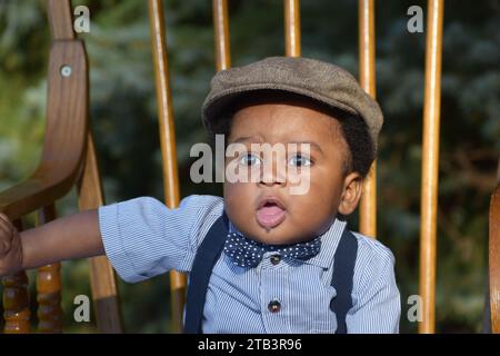 Adorable Cute baby boy in hat, drooling, black baby boy Stock Photo