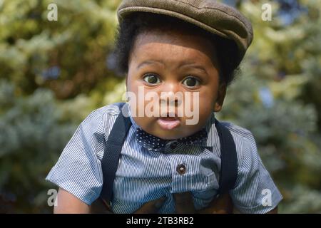 Adorable Cute baby boy in hat, drooling, black baby boy Stock Photo