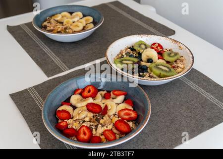an image of various bowls of acai ice cream topped with a selection of healthy fresh fruit and oatmeal. Stock Photo