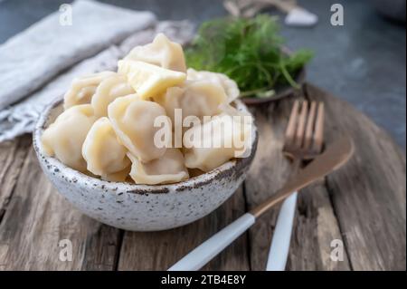 Handmade dumplings with greens in rough, handmade dishes. Close-up. Stock Photo