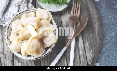 Handmade dumplings with greens in rough, handmade dishes. Close-up. Top view, flat lay, copy space. Stock Photo