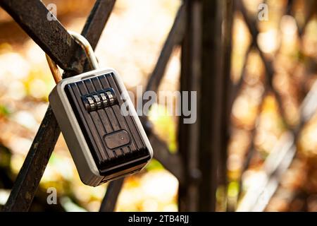 There's a black coded lock hanging on the fence. Private area with limited access. Protected gated area. Stock Photo