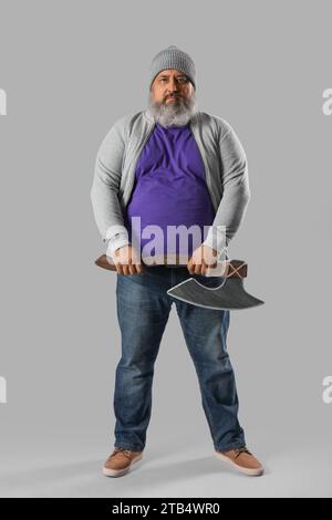Portrait of mature man with axe on grey background Stock Photo
