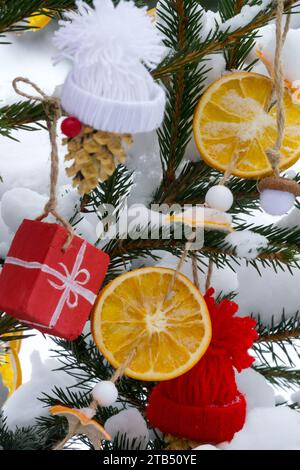 Snow covered, Christmas Ornaments, Hanging, Christmas decoration, Oranges, Outside, Tree, Winter, branches Stock Photo