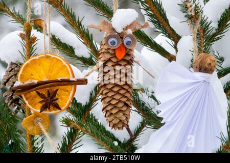 Christmas decoration outside Cinnamon spruce cone hanging on tree twigs snow covered Stock Photo