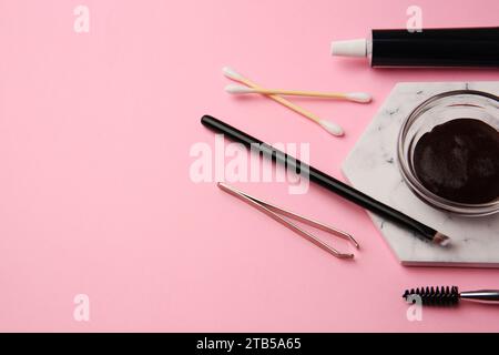 Eyebrow henna and tools on pink background. Space for text Stock Photo