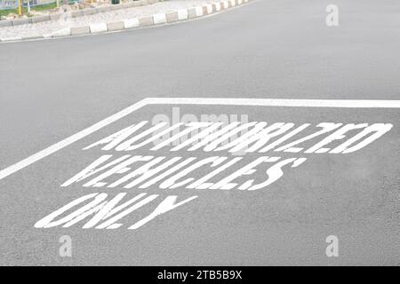 Sign Authorized Vehicles Only painted on asphalt road outdoors Stock Photo