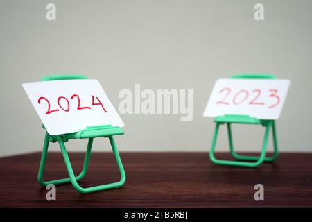 2024 and 2023 cards on mini chairs. change of year from 2023 to 2024. Stock Photo