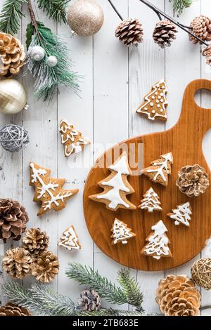Holiday tree shaped gingerbread cookies, surrounded by decorations. Stock Photo