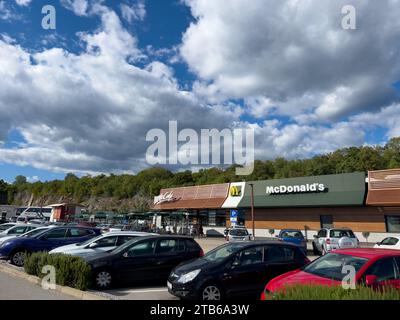 Rome, Italy - 09 august 2023: Cars stand in the parking lot near the McDonalds building Stock Photo
