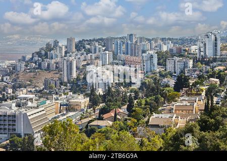 Haifa, Israel - October 22, 2023: Panorama of city buildings, residential area against a background of blue sky with clouds. Stock Photo